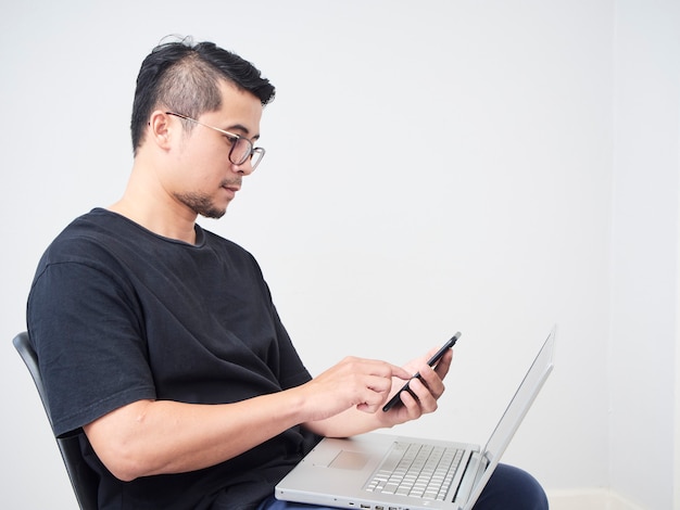 Man works with smartphone and laptop