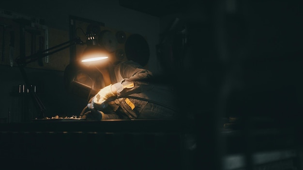 A man works with a welding machine at a factory