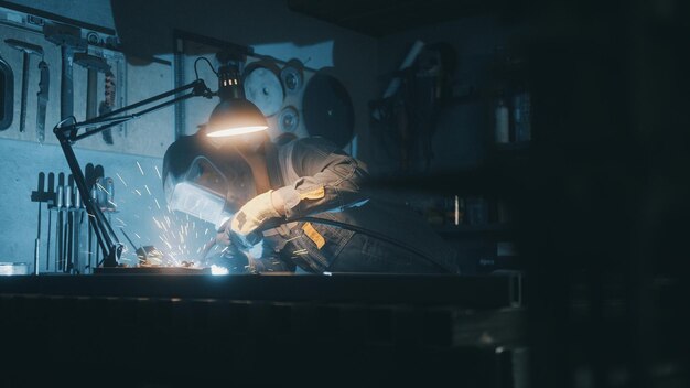 A man works with a welding machine at a factory