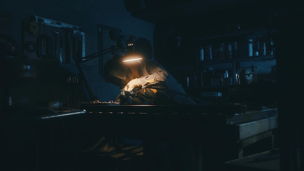 A man works with a welding machine at a factory