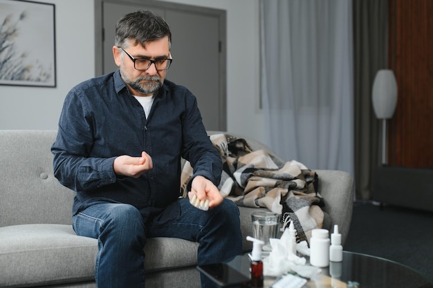 Man wrapped in plaid on the sofa feeling sick illness at home