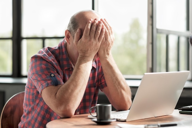 Man wrijft in zijn vermoeide ogen Hij is het zat om op het laptopscherm te kijken