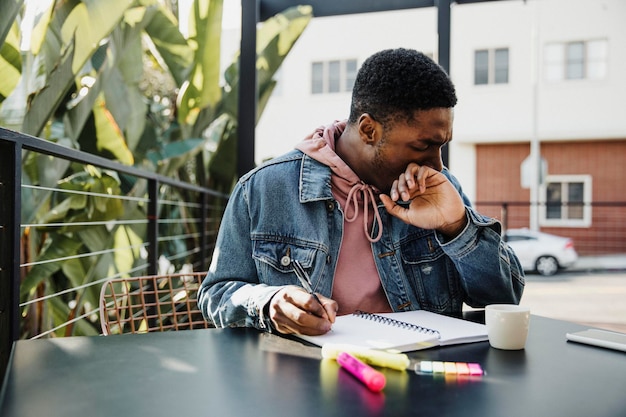 写真 男はカフェで彼のノートに書く