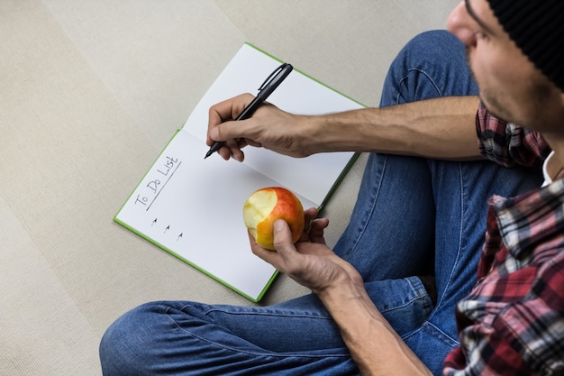 Foto l'uomo scrive per fare la lista in taccuino