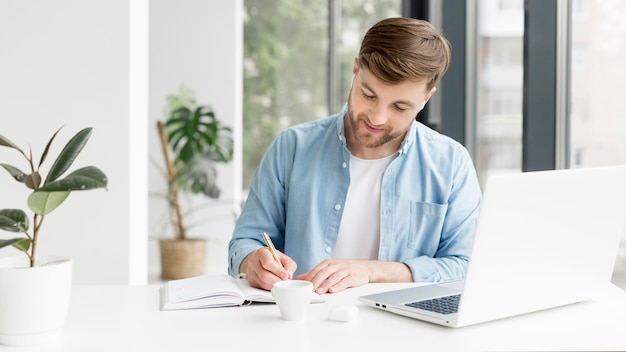 Photo man writing in agenda