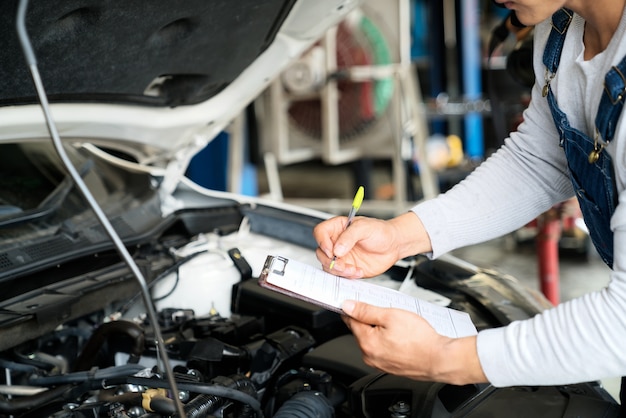 Man writing on a clipboard in a garage