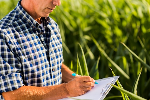 Photo man writing on a clipboard outdoors