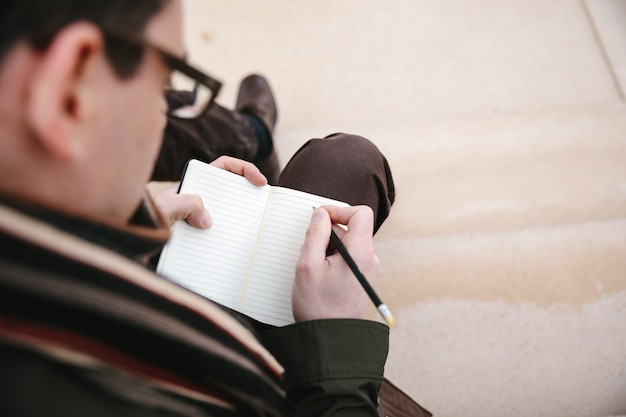 写真 ノートに書いているその男