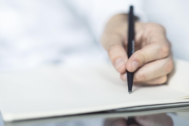 Man writing in notepad Close up Education concept