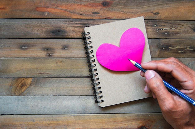 Photo man writing notepad on wood