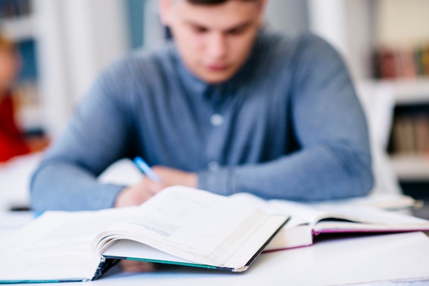 写真 本を持つテーブルに書く男