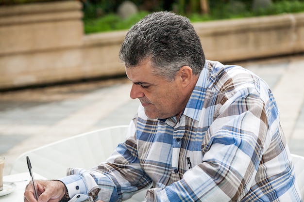 Man writing outdoors