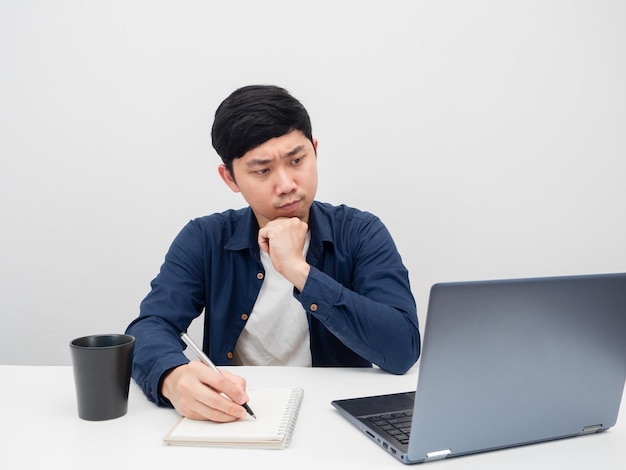 Uomo che scrive e lavora sul posto di lavoro alla scrivania emozione seria