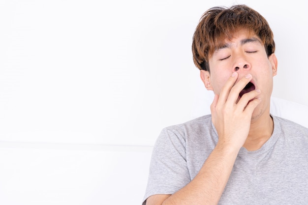 Man yawning and covering mouth with hand