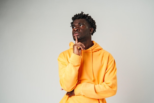 man in yellow hoodie posing for picture thinking