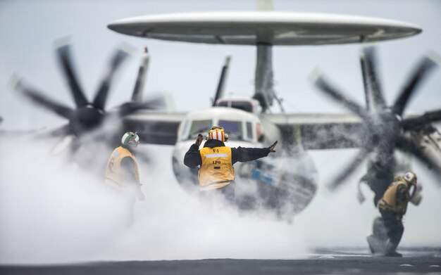 Photo a man in a yellow life jacket is on a plane with a life vest that says  air force