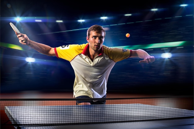 A man in a yellow and red shirt is playing tennis.