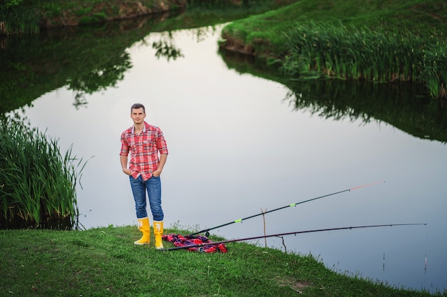 A man in yellow rubber boots and a plaid shirt looks into the frame