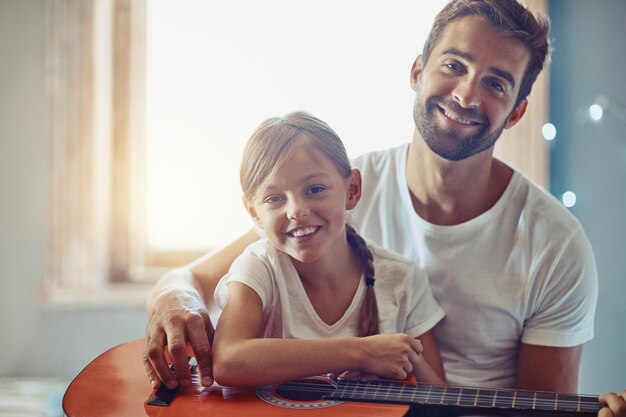 Photo man young girl and guitar with teaching and learning at home bonding with love and creativity in portrait family father and daughter learn to play musical instrument lesson and music education