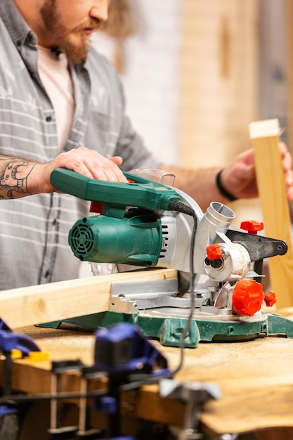 Man zagen hout met een cirkelzaag op een werkbank