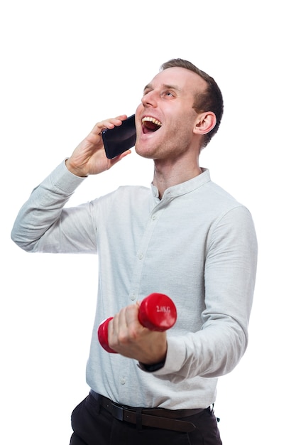 Man zakenman, leraar praten aan de telefoon en sporten houdt een rode halter in de hand. Emotioneel portret. Geïsoleerd op witte achtergrond