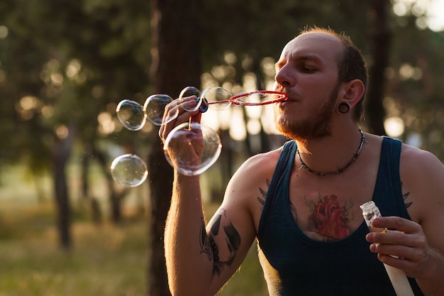 Man zeepbel blazen portret natuur concept. Eenheid met de natuur.