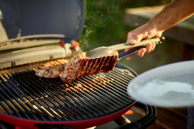 Man zette vlees op een houten bord klaar om gegrild steak vlees te eten,