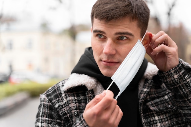 Man zijn medisch masker op het gezicht zetten