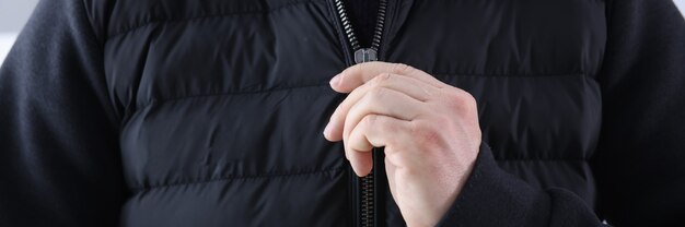 Photo man zips up a black jacket. fashionable and stylish youth clothing concept