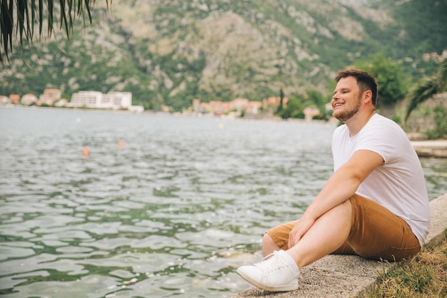 Man zit aan de kust met een prachtig uitzicht op de bergen op de achtergrond zomertijd