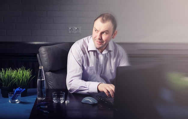 Man zit aan tafel en werkt op laptop