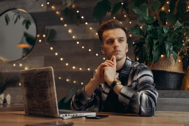 Man zit aan tafel met laptop en denkt aan project