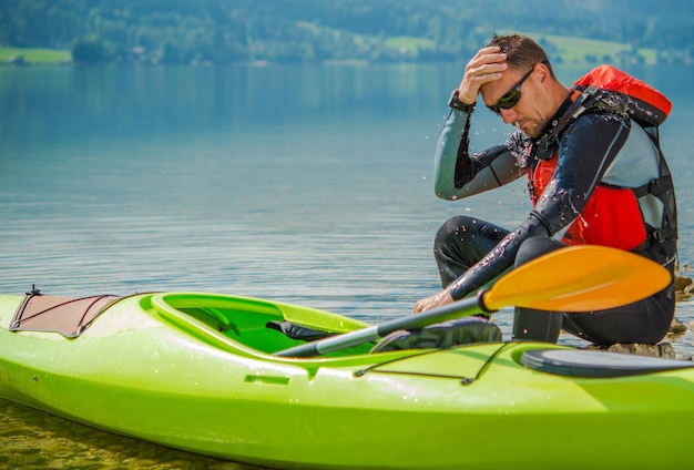 Man zit in een kajak aan de oever van het meer