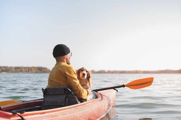 Man zit in een kajak met een hond in de zee
