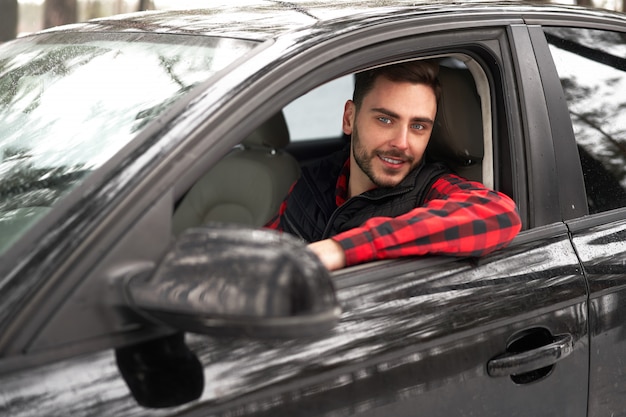 Man zit in zijn auto in een bos