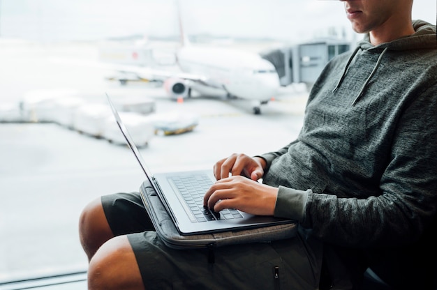 Man zit met laptop op de luchthaven