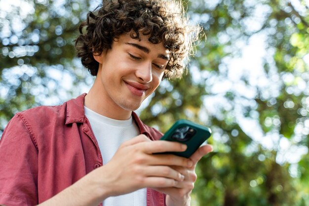 Man zit op de bank op straat en berichten met vrienden op zijn smartphone