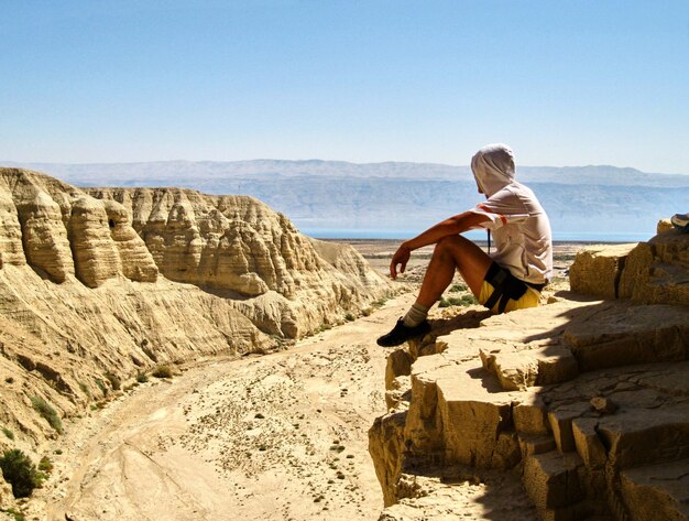 Man zit op een richel. Canyon Ein Avdat in de Negev-woestijn. Israël.