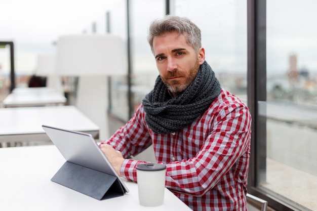 Man zit op een terras voor een tablet