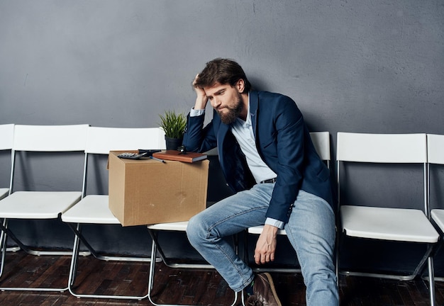 Man zit op een witte stoel te wachten op de depressie van het zoeken naar een baan