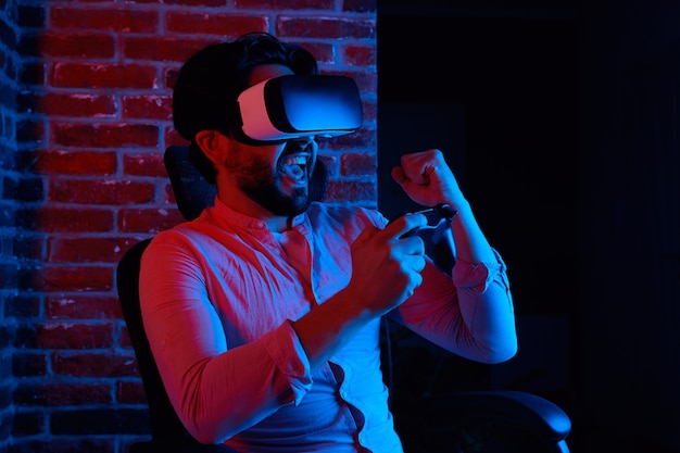 Man zit op stoel en toont ja-gebaar terwijl hij een spel speelt met een vr-bril