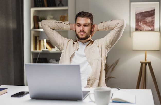 Man zittend aan een bureau met laptop