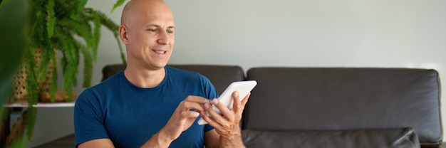 Man zittend op de Bank en het gebruik van digitale tablet. Thuis internetten via tablet.