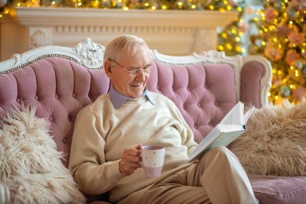 Man zittend op een bank een boek te lezen