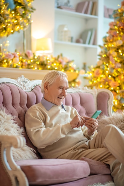 man zittend op een bank met behulp van telefoon