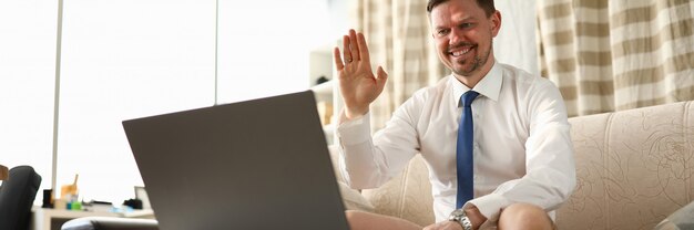 Man zonder broek zit thuis voor laptop