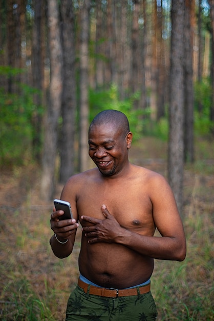 Man zonder een shirt met een smartphone en lachen