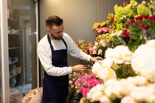 man zorgt voor bloemen in de koelkast in een bloemenwinkel.