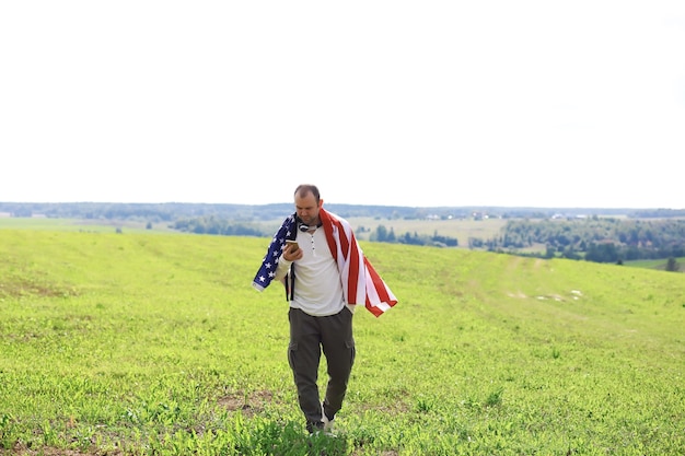 Man zwaaien Amerikaanse vlag staande in gras boerderij landbouwgebied, vakantie, patriottisme, trots, vrijheid, politieke partijen, immigrant