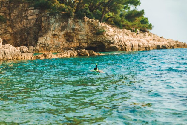 Man zwemmen met snorkelmasker bij blauwe azuurblauwe zeewater kopieerruimte